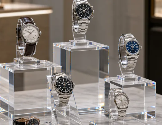 Acrylic watch display stand pedestal set on a boutique counter