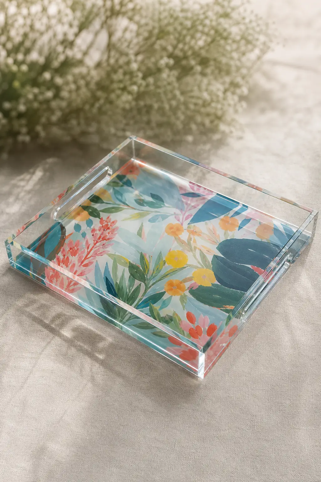 Glossy bottom-printed acrylic artist tray with vivid abstract botanical artwork visible through the transparent PMMA tray body, polished edges catching the light on a neutral linen surface