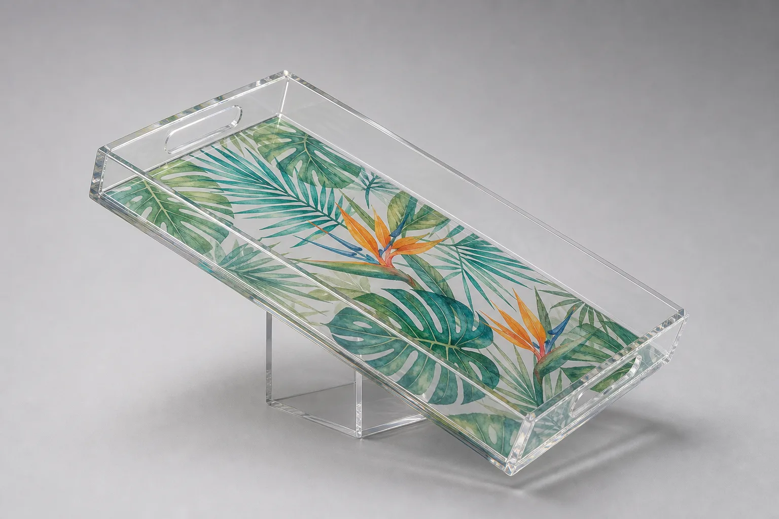 Clear acrylic tray tilted at 45 degrees showing vivid botanical artwork printed on the underside of the PMMA base