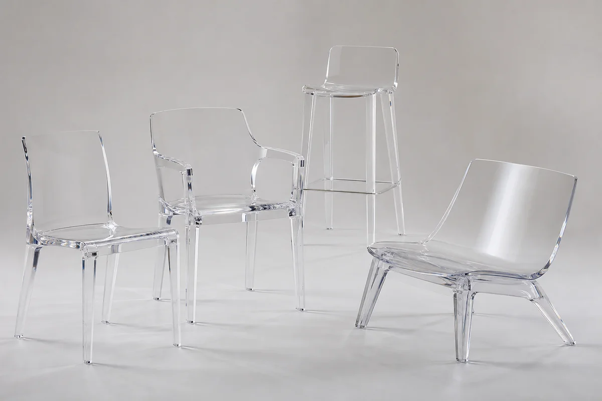 Editorial group shot of custom acrylic chairs in different configurations — side, dining, counter stool, lounge — arranged together on a neutral backdrop