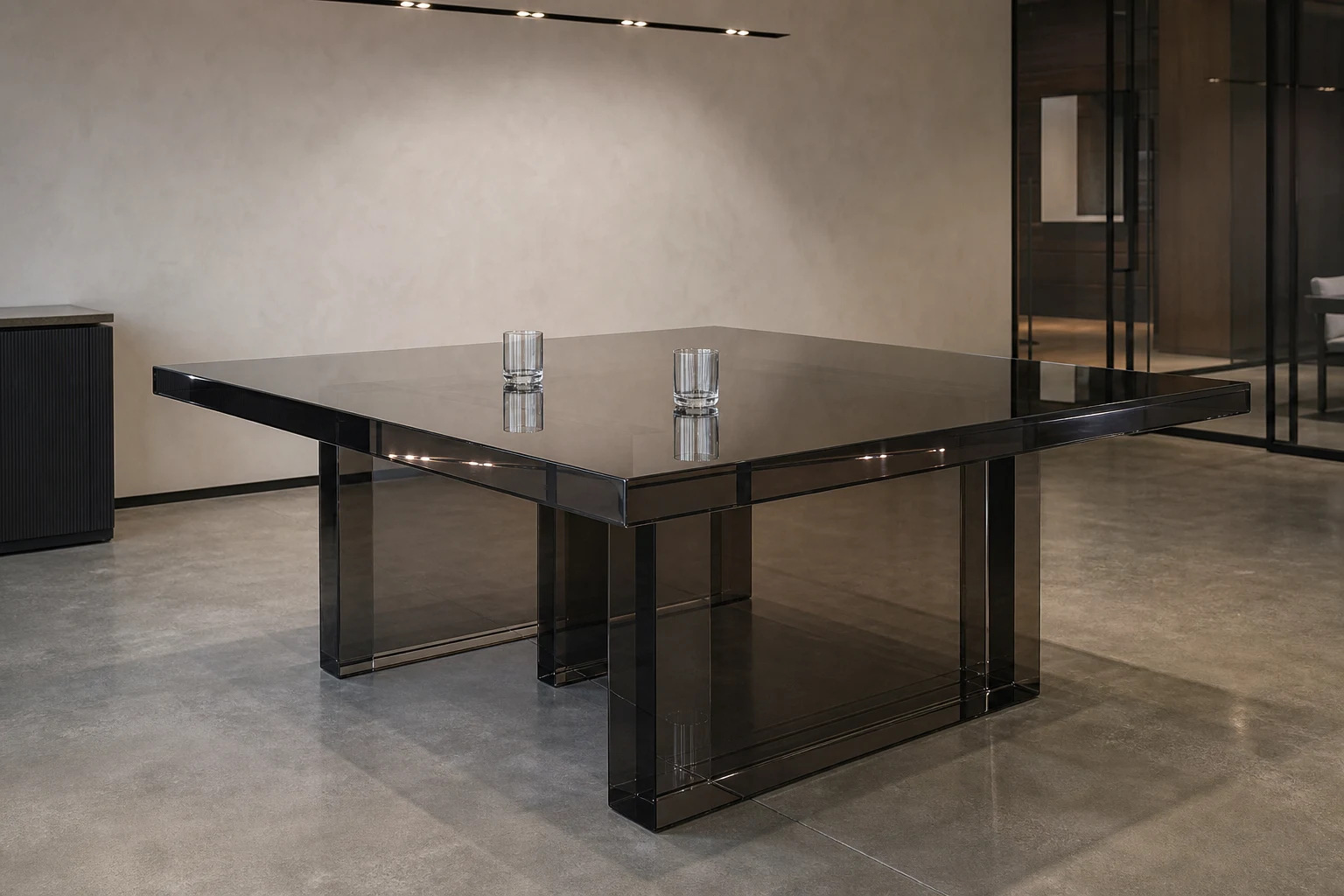 Square clear cast acrylic dining table with chamfered edges in a modernist restaurant private dining room with directional lighting on the table top
