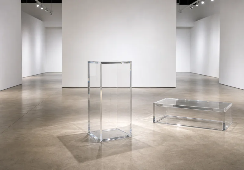 Clear cast acrylic pedestal and display platform in a contemporary gallery exhibition space
