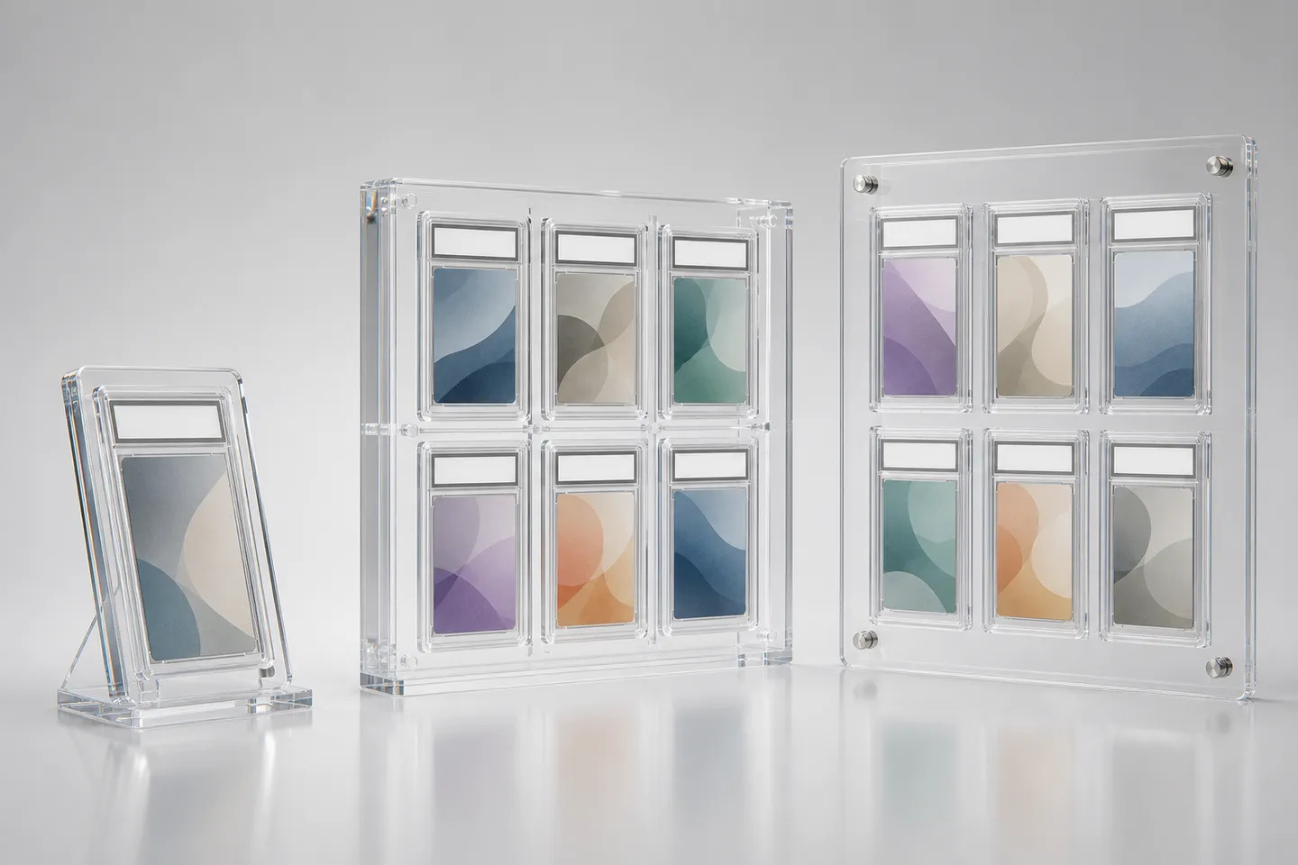 Studio lineup of clear acrylic graded card display cases — a single-slab desktop stand, a 6-slot multi-slab grid display, and a wall-mount slab rack, each holding generic encapsulated graded card slabs